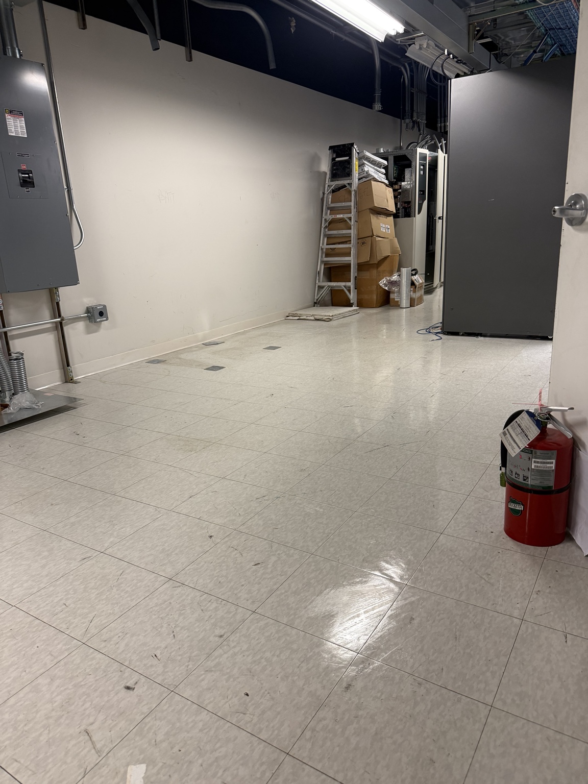 Clean white tiled floor reflecting the overhead lights after cleaning